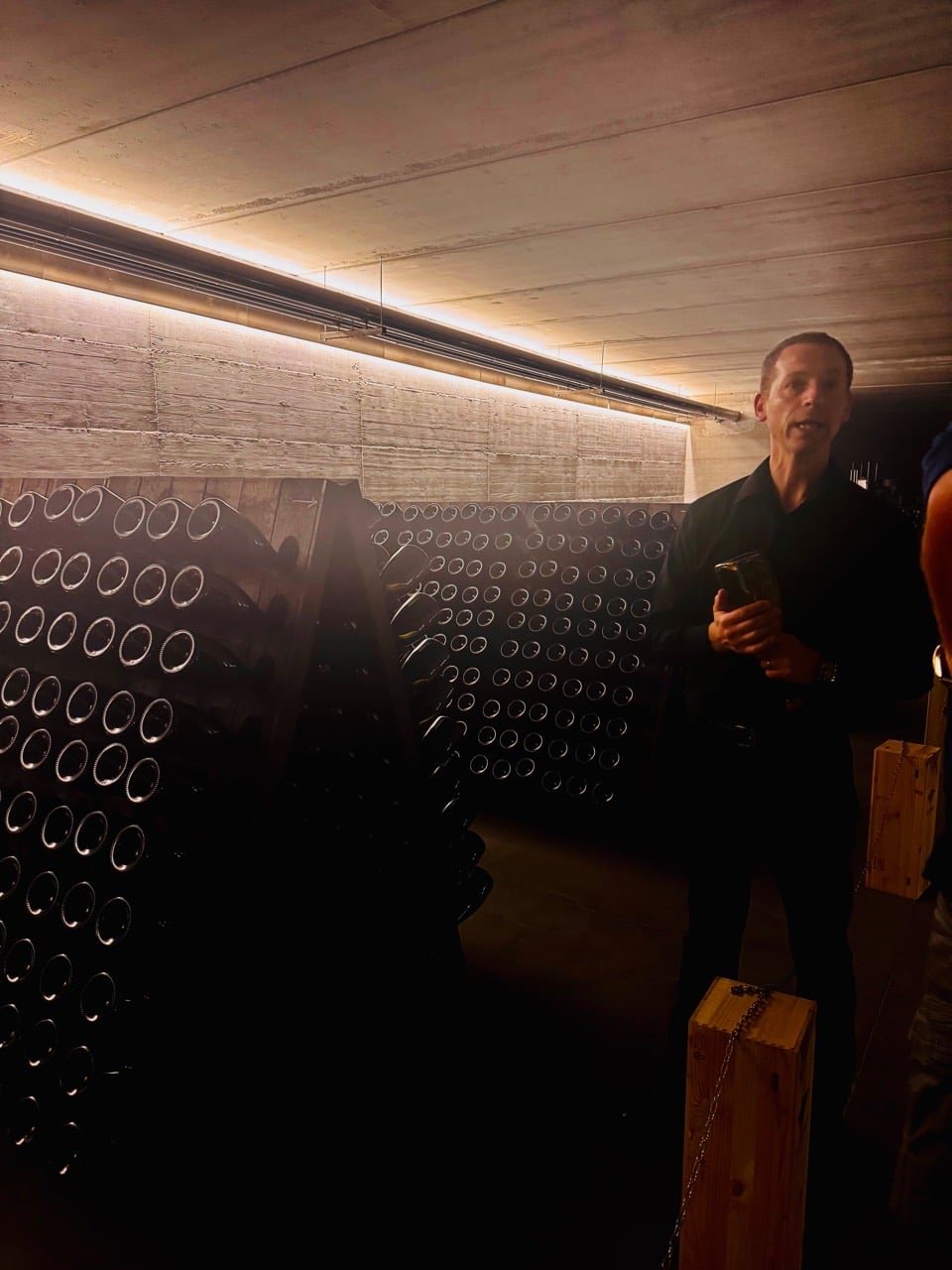 Flaviano guiding the tour among rows of bottles in the underground cellar